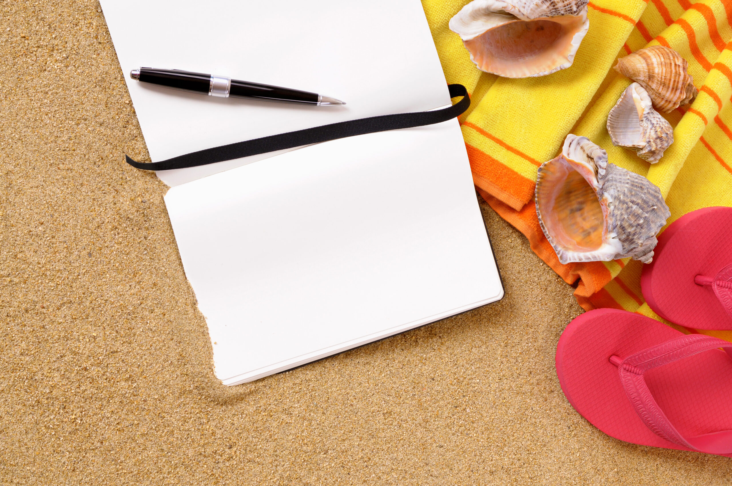 Beach background with yellow towel, flip flops and blank writing book